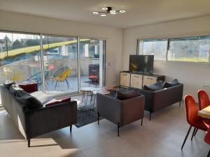 a living room with couches and a flat screen tv at Appartement Thiou in Sévrier