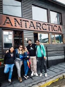 a group of people standing in front of a restaurant at Antarctica Hostel in Ushuaia