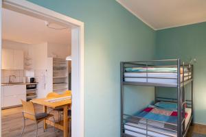 a bedroom with a bunk bed and a dining room with a table at Harzquartier in Friedrichsbrunn