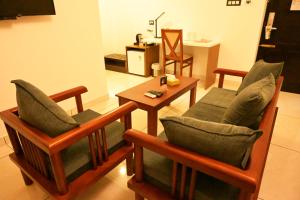 a living room with two chairs and a table at Hotel Thamburu International in Trivandrum