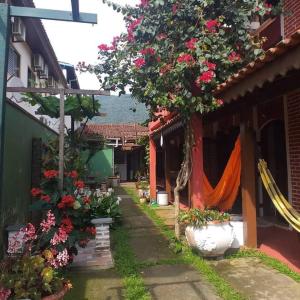 an alley with flowers in pots next to a building at Chale Colonial in Ubatuba
