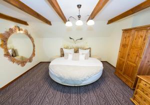 a bedroom with a large bed and a mirror at Rancho Pod Bocianem in Przypki