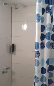 eine Dusche mit einem blauen und weißen Duschvorhang in der Unterkunft Hotel Berkut in Fürth