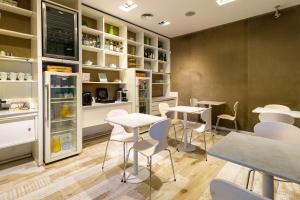 a restaurant with white tables and chairs and shelves at CasaCalma Hotel in Buenos Aires