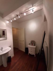 bagno con lavandino, specchio e luci di Chateau Sourliavoux, appartement en chambres d'hôtes a Vallières