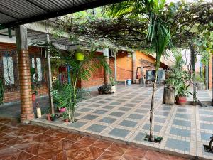 un patio con palmeras y un edificio de ladrillo en Apart Nicolas, en Puerto Iguazú