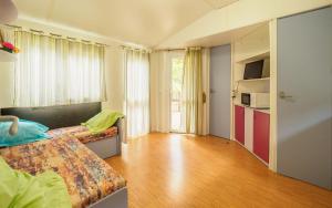 TivissaにあるCamping Alberg Municipal Tivissaのベッド2台、キッチンが備わる広い客室です。