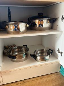 three pots and pans sitting on a shelf in a kitchen at CABANA DO SOL in Torres Vedras