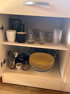 a shelf with plates and bowls and other dishes at CABANA DO SOL in Torres Vedras