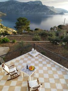 un patio con mesa y sillas y vistas al lago en Terra Calma en Kalymnos