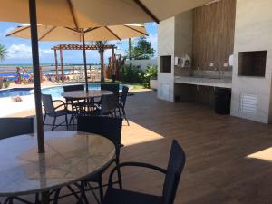 a restaurant with tables and chairs and a swimming pool at PLAGE DU PORTO 204- Beira mar, centrinho turístico in Porto De Galinhas