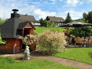 a log cabin with an umbrella in a yard at Gasthof "Zum Burghof" in Medebach