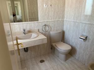 a bathroom with a toilet and a sink and a mirror at Apartment Madrid Barajas in Madrid