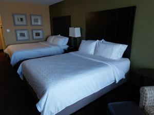 two beds in a hotel room with white sheets and pillows at Holiday Inn Express Hotel & Suites Lansing-Dimondale, an IHG Hotel in Dimondale