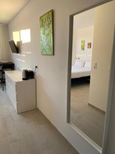 espejo en una habitación con 1 cama y 1 dormitorio en LES JARDINS D'ATHENA, en Aix-en-Provence