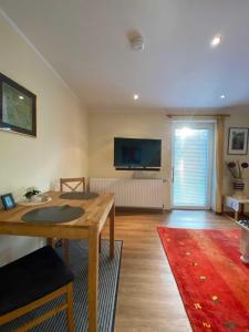 un soggiorno con un tavolo e una televisione a parete di App 3 a List