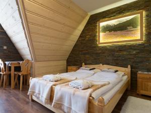 dwa łóżka w pokoju z ceglaną ścianą w obiekcie Willa Daglezja w Zakopanem