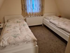 two twin beds in a room with a window at fewo-brigitte in Buxtehude
