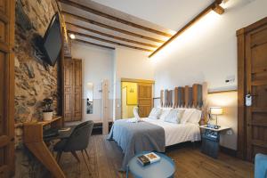 a bedroom with a bed and a desk and a chair at La Casa del Médico Hostería Rural in Urda
