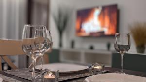 zwei Weingläser auf einem Tisch mit einem Fernseher in der Unterkunft Cervinia Apartment 2121 - Ski & Mountain Panorama in Breuil-Cervinia