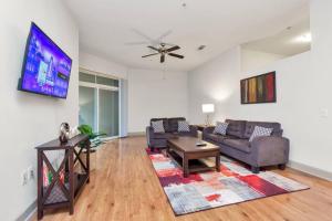 a living room with two couches and a flat screen tv at Stylish Open Concept Apt with King Bed, walking distance from NRG Texans Stadium, 1 mile to Med Center, Free Parking in Houston