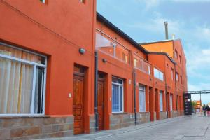 ein orangefarbenes Gebäude mit Fenstern auf einer Straße in der Unterkunft Maipu Alquiler Por Dia in Río Gallegos