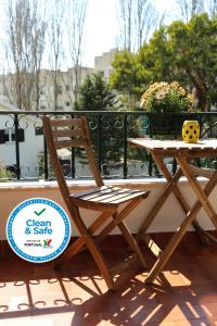 une chaise en bois assise à côté d'une table sur un balcon dans l'établissement Paradise Suites, à Carcavelos