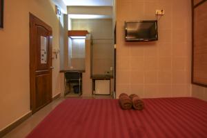 a room with two pairs of shoes on a red rug at Bar Oz Riverside Guesthouse in Phnom Penh