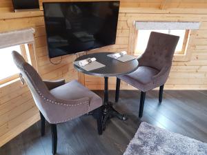 mesa, 2 sillas y TV en una habitación en Unique luxury cabin 2 en Inverness