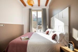 a bedroom with a large white bed with a window at Aspasios Market Balconies Apartments in Barcelona