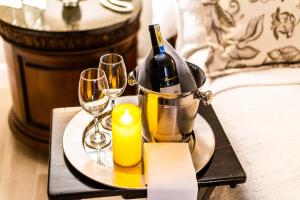 a tray with a bottle of wine and glasses on a bed at Casa García in Guayaquil