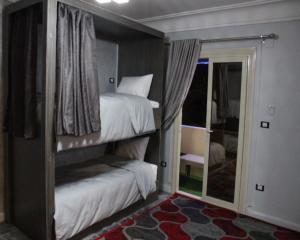 um quarto com 2 beliches e uma janela em Hostel Sunset Down town em Cairo