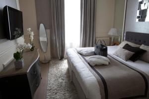 a bedroom with a large bed and a television at Best Western Premier Grand Monarque Hotel & Spa in Chartres