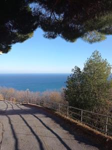 an empty road with the ocean in the background at Casa Baia Azzurra in Bergeggi