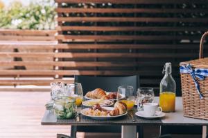 a table with a breakfast of croissants and orange juice at Praia do Sal Resort & SPA in Alcochete