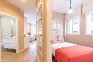 niewielka sypialnia z łóżkiem i łazienką w obiekcie Plaza Nueva Deluxe Suite by Valcambre w Sewilli
