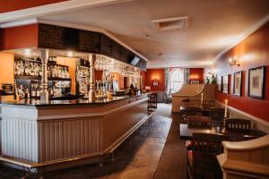 a bar in a restaurant with a counter and chairs at The Boar's Head in Harrogate