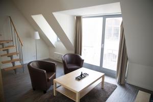 a living room with two chairs and a table and a window at Domblick Schwerin in Schwerin