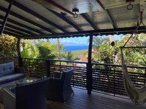 een balkon met een hangmat en uitzicht op de oceaan bij Domaine Karaibes in Deshaies