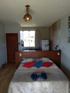 1 dormitorio con 1 cama grande con almohadas rojas y azules en Chalé Paz Central do Paraíso Lapinha da Serra, en Santana do Riacho