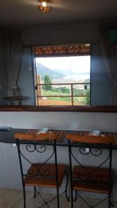 due tavoli davanti a una finestra con vista di Chalé Paz Central do Paraíso Lapinha da Serra a Santana do Riacho