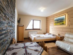 sypialnia z 2 łóżkami i ceglaną ścianą w obiekcie Willa Daglezja w Zakopanem