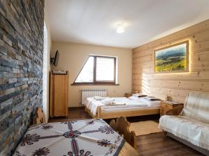 a bedroom with two beds and a brick wall at Willa Daglezja in Zakopane