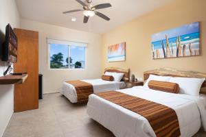 a hotel room with two beds and a ceiling fan at Villa Sofia Boutique Hotel Cancun in Cancún