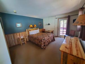 a bedroom with a bed and a table and a table sidx sidx sidx at Swiftcurrent Lodge in Estes Park