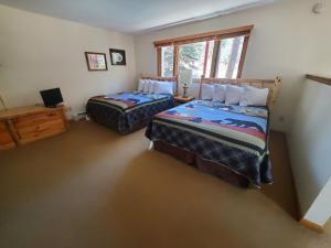 a bedroom with two beds and a window at Swiftcurrent Lodge in Estes Park