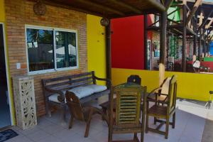 um banco sentado fora de um restaurante com uma mesa e cadeiras em Vila Catuaí - 06 charmosos chalés há menos de 100m da Praia de Maracaípe em Porto de Galinhas