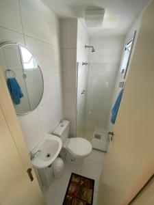 a bathroom with a toilet and a sink and a mirror at Costa Maggiore Residencial Resort in Cabo Frio