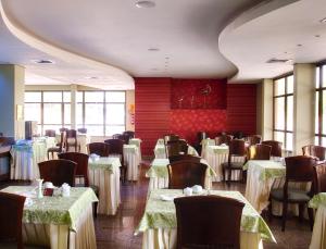 a dining room with tables and chairs with white table cloth at Pousada dos Girassóis in Palmas