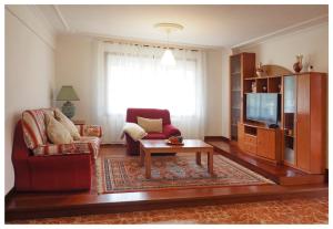 een woonkamer met een bank en een tv bij O FOGAR DE LENI in Pontevedra